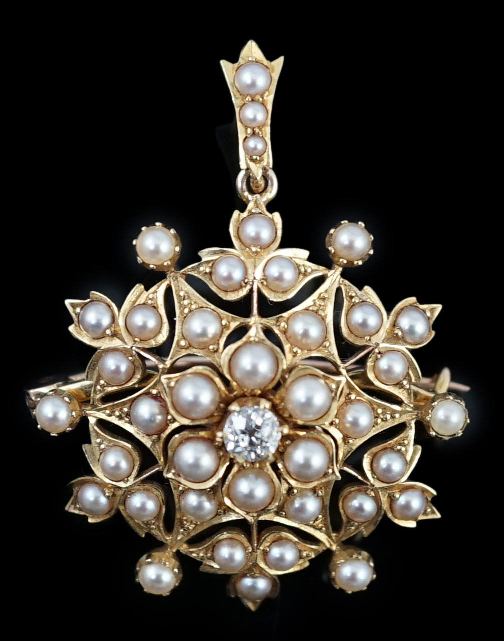 An Edwardian single stone diamond and seed pearl cluster set pendant brooch